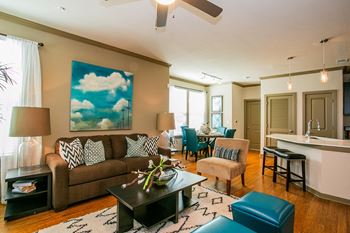 a living room with a brown couch and blue chairs